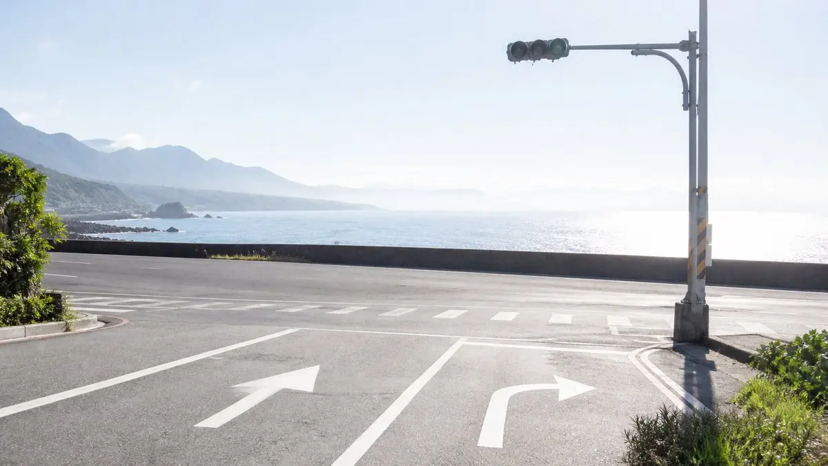 濱海公路上的十字路口,地面有直行與轉彎的箭頭
