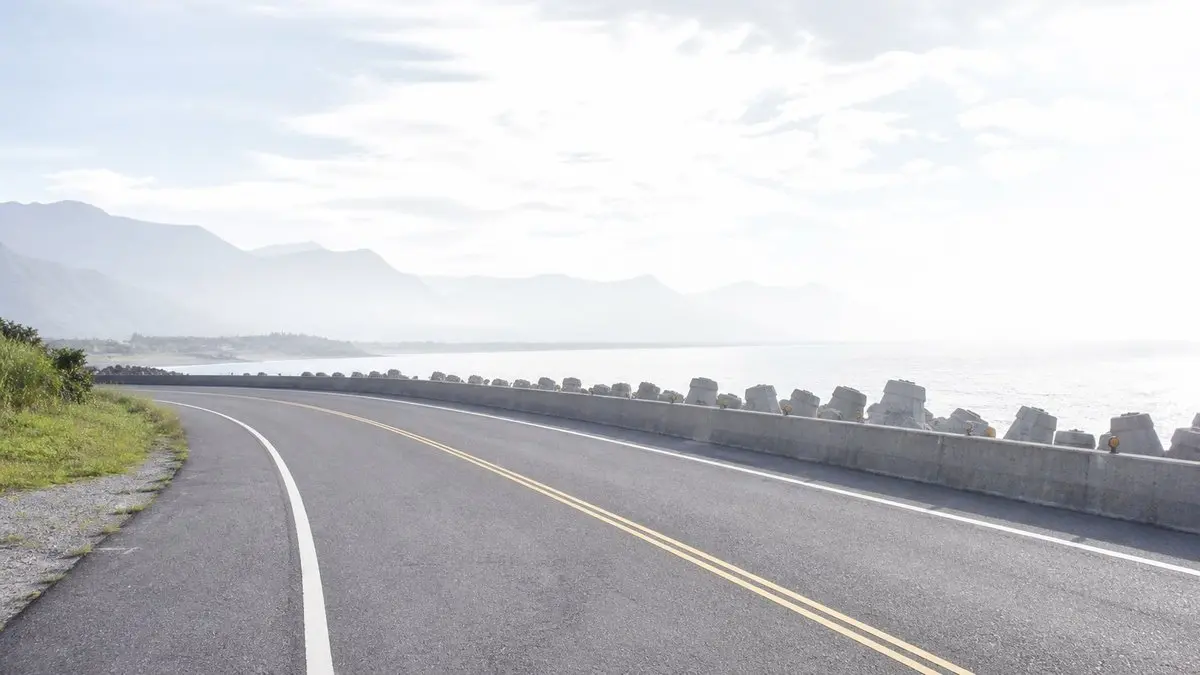 早上九點的濱海公路,海堤上排著一整排消波塊,遠方是薄霧中的山與海